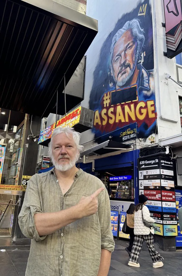Julian Assange Poses in Front of Mural Depicting Him in Sydney
