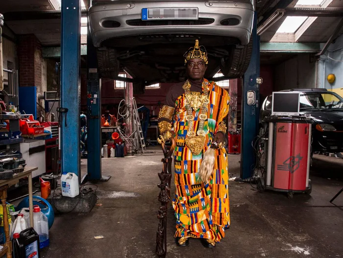 This is king Céphas Bansah, who rules over ~200k people in his kingdom in Ghana. He came to Germany to learn "duty, discipline, diligence, and ambition" and works as a car mechanic