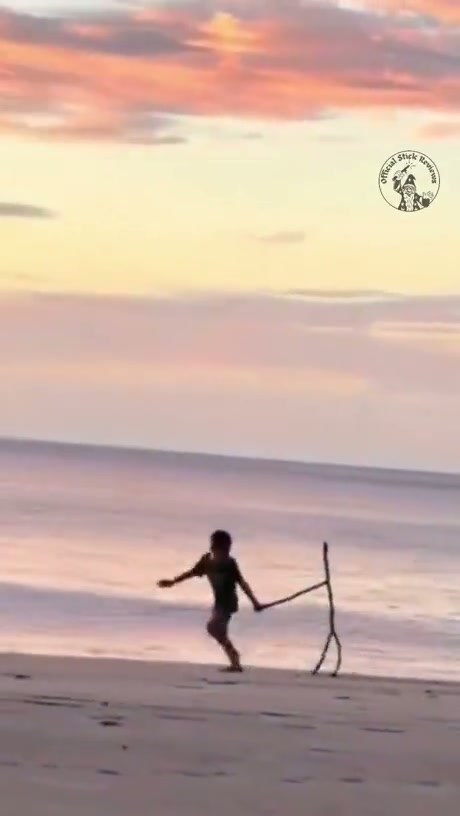 A Young Boy Takes His Unique Stick Friend for a Beach Walk
