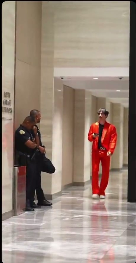 Man in Bright Red Suit Performs Dance Moves in Public Spaces