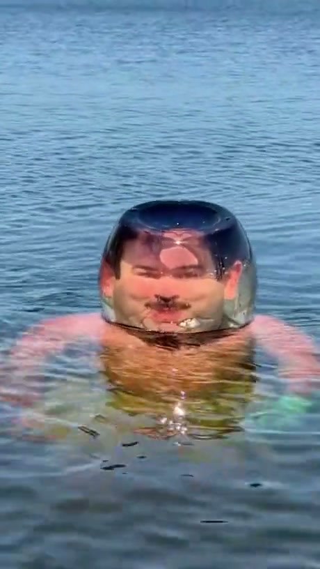 Man Wears a Glass Bowl Over His Head While Swimming