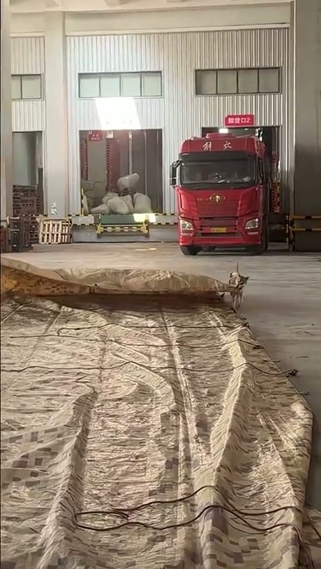 Hardworking Dog Helps Warehouse Worker Roll Up Heavy Tarp