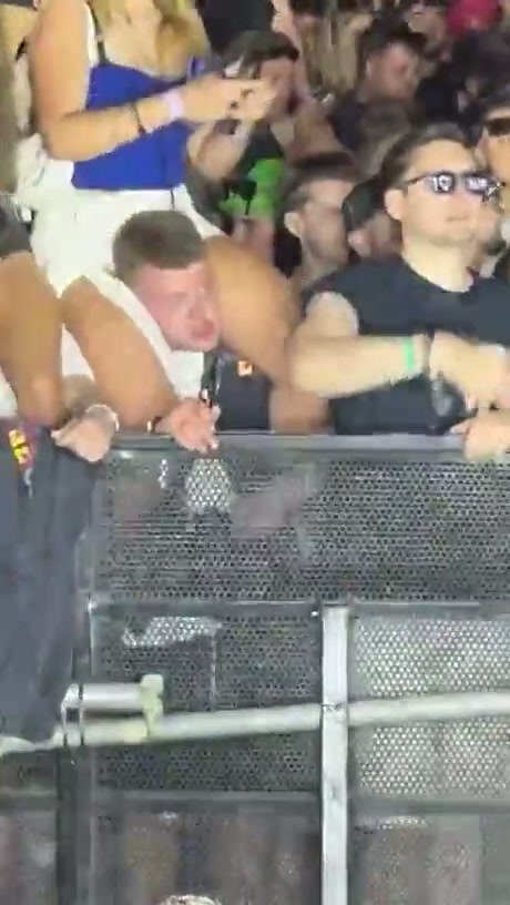 Concert Attendee Struggles While Carrying Someone on Shoulders