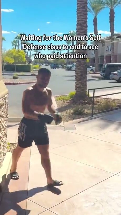 A Shirtless Man in Sandals Practices His Boxing Moves Outside a Building